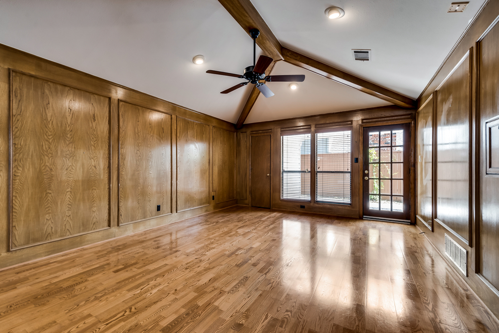    Beamed Ceiling Wood Paneling and Door to Covered Back Patio Round out the Space 